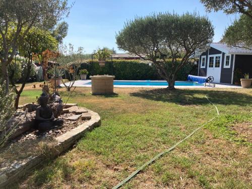 une cour avec une piscine et une cour avec une aire de jeux dans l'établissement LE CARABIOL - Chambre d'Hôte, à Saint Julien Les Rosiers