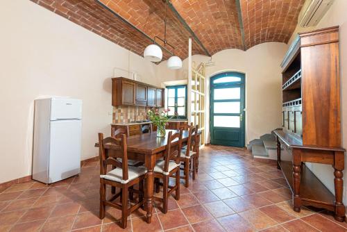 a kitchen with a table and chairs and a refrigerator at Salvapiano Holiday Ranch in Riotorto