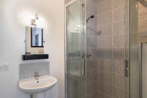 une salle de bain avec un lavabo et une douche en verre dans l'établissement YOKOSO - Studio proche CHU avec terrasse, à Rennes
