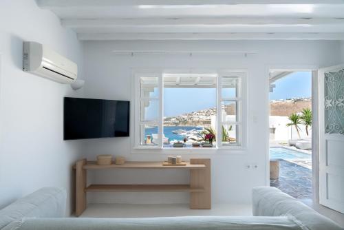 a white living room with a view of the ocean at myMykonos Villa I in Platis Gialos