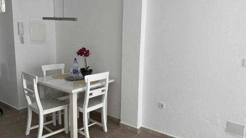 a white dining room table with chairs and a bottle of water at Apartamento Kalma 1 in Corralejo