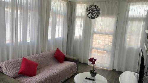 a living room with a couch and a table with red pillows at Apartamento Kalma 1 in Corralejo