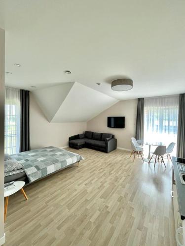 a bedroom with a bed and a couch and a table at Apartamentai Klaipėda-studijos tipo butukai in Klaipėda