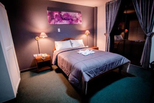 a hotel room with a bed and two lamps at Saint Germain Hotel in Trujillo