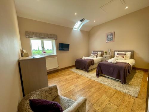 ein Zimmer mit 2 Betten und einem Sofa darin in der Unterkunft Fieldsview in Wrexham