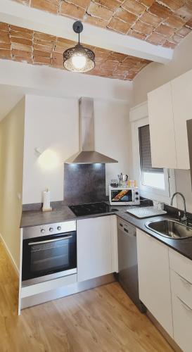 a kitchen with white cabinets and a stove top oven at Apartamentos MIRADOR DEL TRANSITO in Toledo