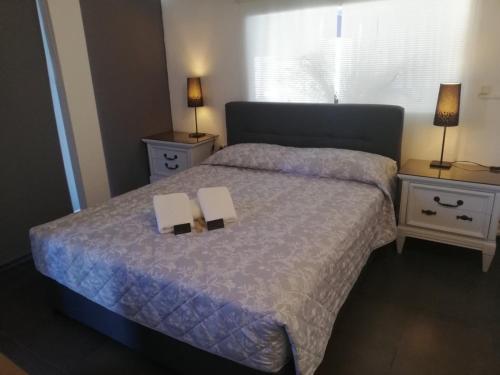 a bedroom with a bed with two books on it at Luxury Loft in Porto Heli !!! in Porto Heli