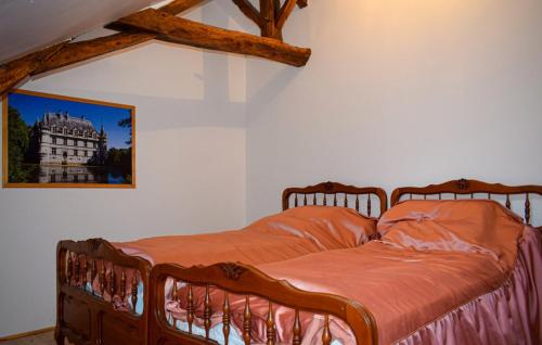 a bedroom with a wooden bed with a picture on the wall at Maison de 3 chambres avec jardin clos et wifi a Channay sur Lathan in Channay-sur-Lathan