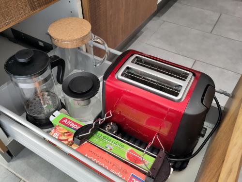 a red toaster sitting in a drawer in a kitchen at Le Gite de la Loire in Rochecorbon