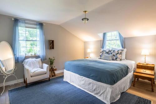 a bedroom with a bed and a chair and a mirror at French Riviera-Style Country Waterfront Cottage in Sparta