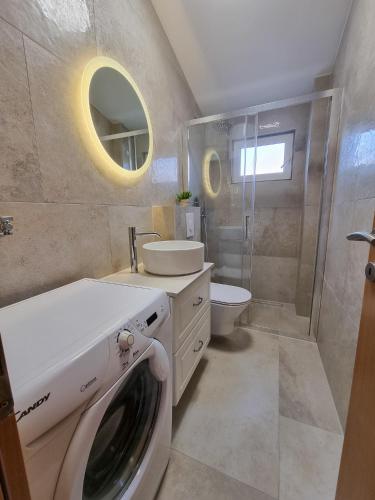 a bathroom with a washing machine and a sink at Apartments Bagić in Vir