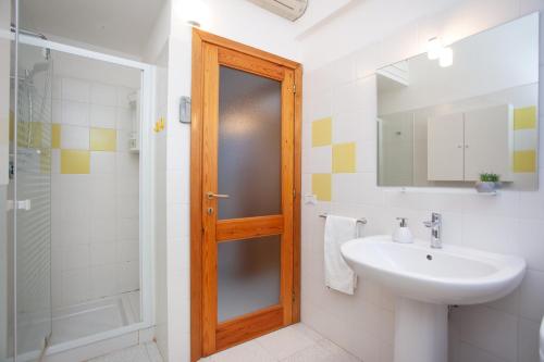 a bathroom with a sink and a shower and a mirror at Villetta Le Rose in San Teodoro