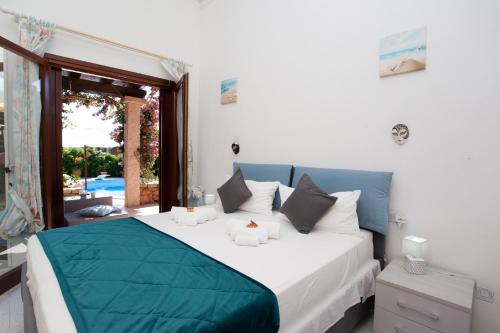 a bedroom with a blue and white bed and a window at Villetta Le Rose in San Teodoro