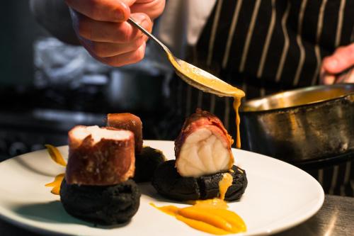 a person is eating food on a plate at 5 Corners Guest Inn in Ballyclare