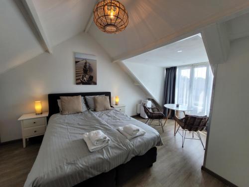 a bedroom with a large bed with towels on it at Sleep Well Ness Domburg in Domburg