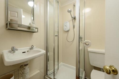 uma casa de banho com um lavatório e um chuveiro em Cosy Dean Village Studio em Edimburgo