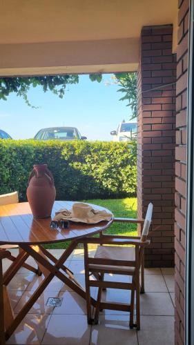 a table and chairs on a patio with a vase on it at Evita Maisonette, Elegant Beachfront apt, Polychrono in Polykhrono