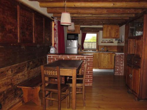 una cocina con mesa de madera y sillas. en Alloggio Gran Paradiso, en Aosta