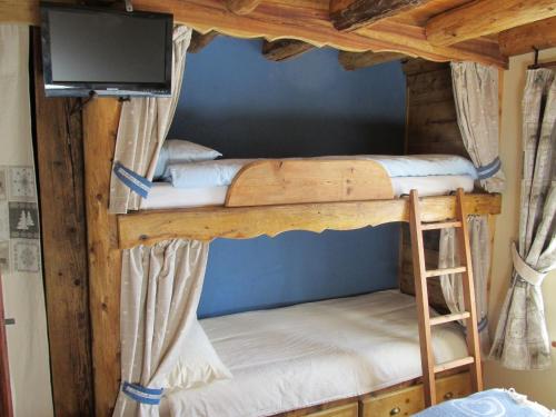 two bunk beds in a room with a flat screen tv at Alloggio Gran Paradiso in Aosta