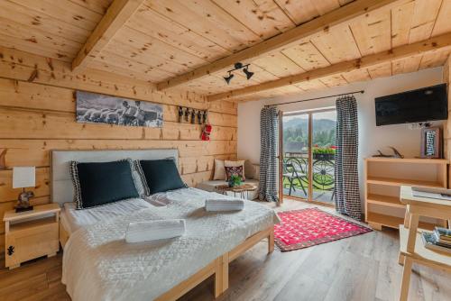 ein Schlafzimmer mit einem Bett in einem Holzzimmer in der Unterkunft Apartamenty Truchanówka przy Dolinie Chochołowskiej in Witów