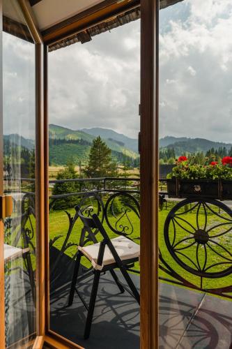 a balcony with a chair and a view of the mountains at Apartamenty Truchanówka przy Dolinie Chochołowskiej in Witów