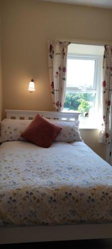 a bedroom with a bed with a window at Luxury 3 bedroom house with peaceful garden, sleeps 6 and 2 mins to beach in Bundoran