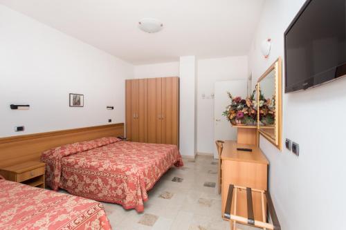 a hotel room with two beds and a flat screen tv at Hotel Residence Des Bains in Cesenatico