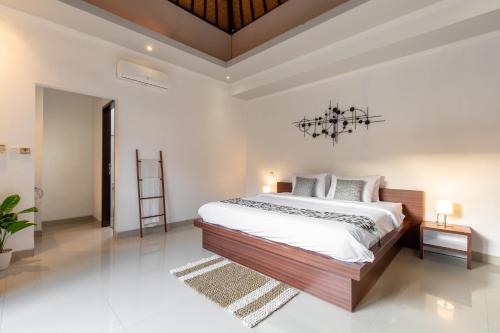 a bedroom with a large bed and a chandelier at Villa Estella ☆ Seminyak Kuta - Private Pool in Seminyak