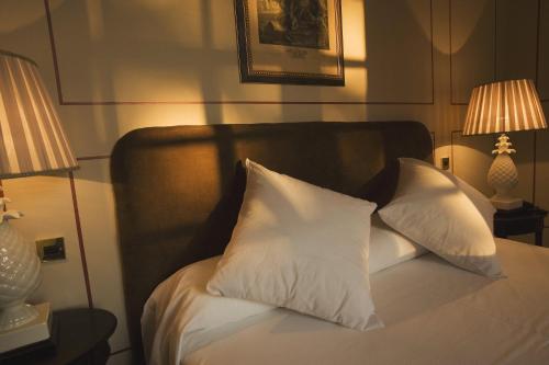 a bed with two pillows on it with two lamps at Posada Real Casa de Tepa in Astorga