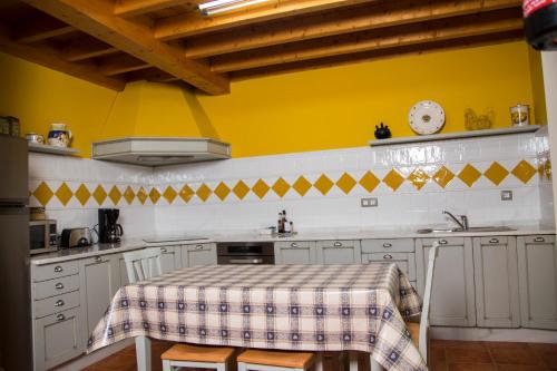 cocina con mesa y pared amarilla en Casa Azulete, en Bimenes