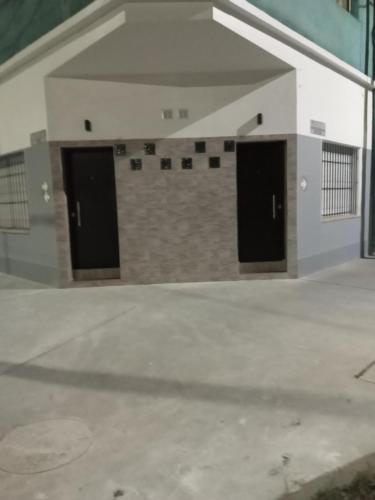 a garage with two black doors on a building at Monoambientes in Villa Alsina