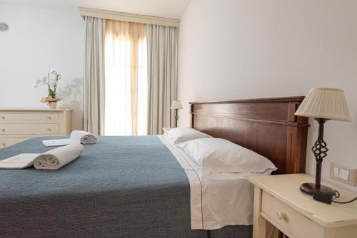 a bedroom with a large bed with towels on it at Salvapiano Holiday Ranch in Riotorto