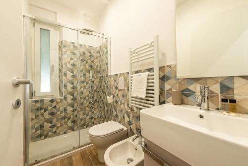 a bathroom with a toilet and a sink and a shower at B&B Interno12 in Follonica