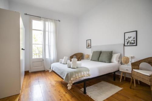 um quarto com uma cama com lençóis brancos e uma janela em 21par1005 - Beautiful Apartment in Paral-lel em Barcelona