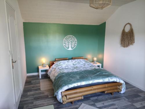 ein Schlafzimmer mit einem Bett mit einer grünen Wand in der Unterkunft Détente au bord du Loir - Gîte 2 in Les Roches-lʼÉvêque