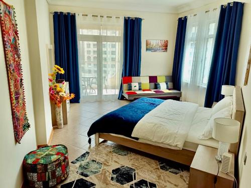 Luxury Apartment Palm Jumeirah في دبي: غرفة نوم بسرير ونافذة ذات ستائر زرقاء
