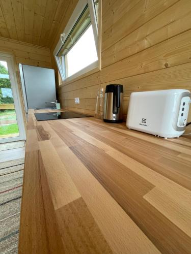 a room with a kitchen with a coffee maker on a wooden floor at Widokówka Kaszuby in Mirachowo