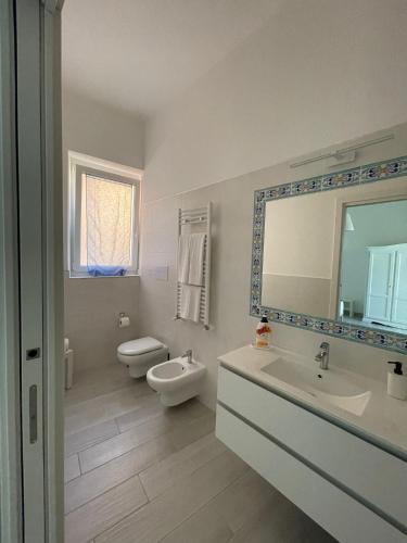 a bathroom with a sink and a toilet and a mirror at B&B ROSSELLA Vietri in Vietri sul Mare
