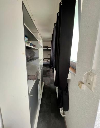 an empty room with a hallway with a refrigerator at Pension des Draizes in Neuchâtel