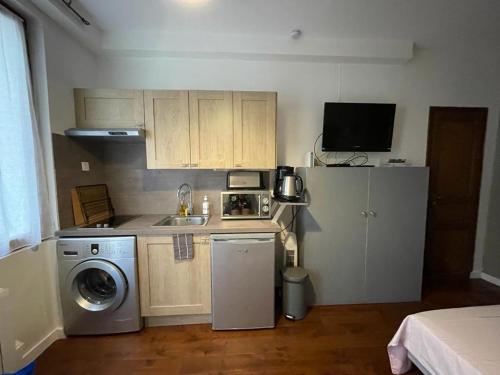 Il comprend une petite cuisine équipée d'un réfrigérateur et d'un lave-linge. dans l'établissement Studio Saint-Placide, à Paris