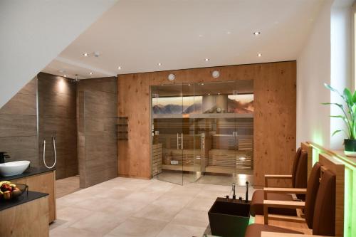 bagno con pareti in legno e doccia in vetro di Hotel Alpenfrieden a Kappl