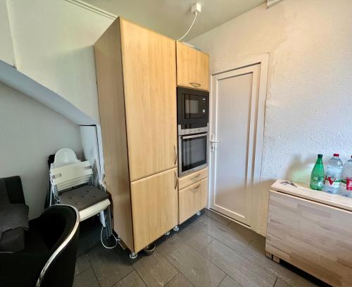 a small kitchen with a cupboard and a microwave at Pension des Draizes in Neuchâtel