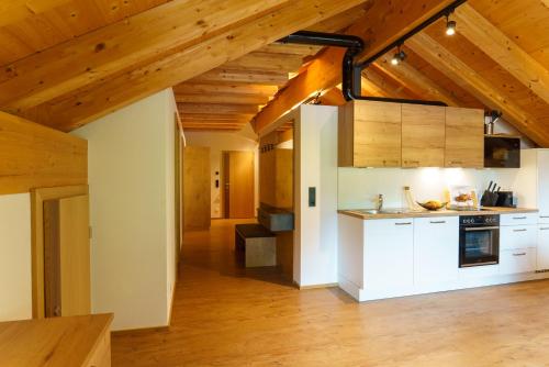 una cucina con armadi bianchi e soffitti in legno di Hotel Alpenfrieden a Kappl