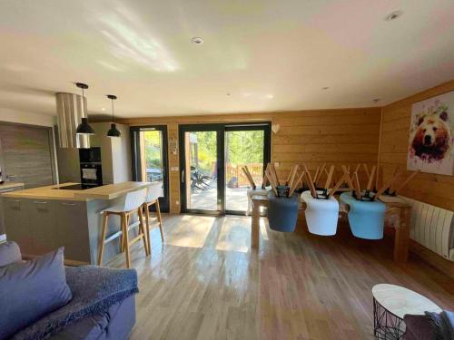 uma cozinha e uma sala de estar com um grupo de cadeiras em Chalet de 5 chambres avec sauna jardin clos et wifi a Les Orres em Les Orres
