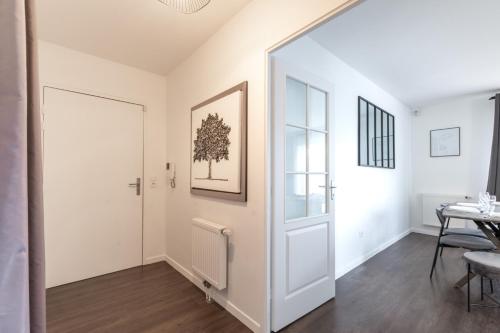 an open hallway with a white door and a table at La Canopée By Plaza in Serris