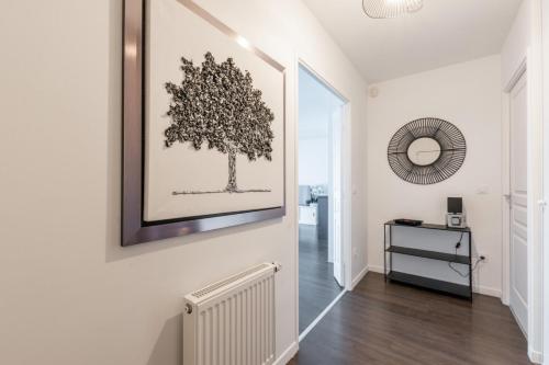 a hallway with a picture of a tree on the wall at La Canopée By Plaza in Serris
