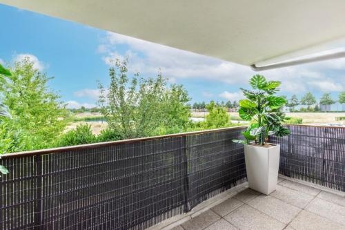 a balcony with a plant in a white pot at La Canopée By Plaza in Serris
