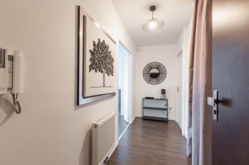a hallway with white walls and a picture on the wall at La Canopée By Plaza in Serris
