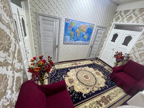 a room with a couch and a table with flowers at Bruce hostel in Dushanbe