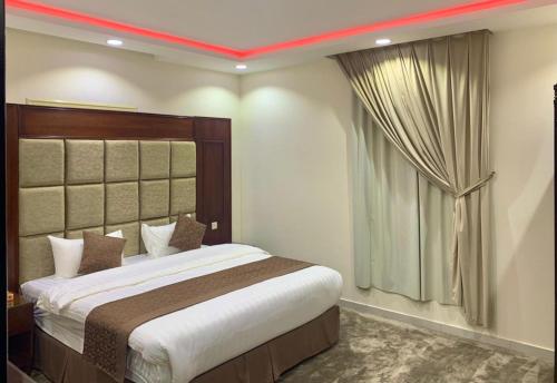 a bedroom with a large bed and a window at برادايز للاجنحة المخدومة in Khamis Mushayt